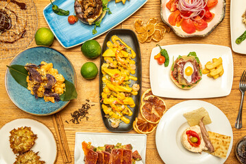 Wall Mural - Top view image of nice spanish food dishes, burgers and tapas on wooden table