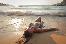 Young Woman Lying On The Beach