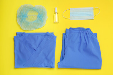 Poster - Flat lay composition with medical uniform and face mask on yellow background