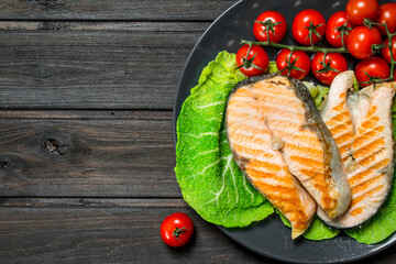 Canvas Print - Grilled salmon steaks with tomatoes on a plate.