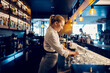 © Dusan Petkovic - A bartender is working with clean glasses behind a counter in a bar.