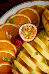 Wall Mural - passion fruit lies on an orange and pineapple, close-up