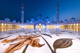 Fototapeta Sawanna - Symmetrical view during the blue hour of the majestic Sheik Zayed mosque in Abu Dhabi shot using a wide angle lens