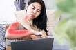 © doucefleur - Asian woman suffering from neck pain spreading to shoulder and down arm caused by overworked on a computer with bad posture