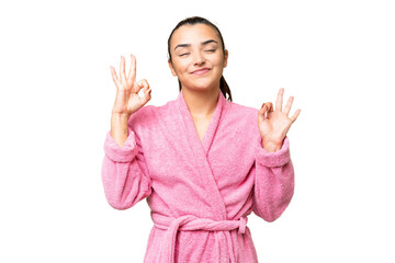 Wall Mural - Young woman in a bathrobe over isolated chroma key background in zen pose