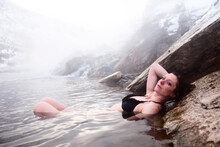 A Beautiful Woman Relaxing In A Hot Springs Waterfall In Montana.