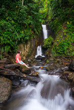 A Woman Relaxes By A Beautiful Waterfall In Trafalgar At The Papillote Wilderness Retreat At The Terminus To Segment 3 Of The Waitukubuli National Trail On The Caribbean Island Of 