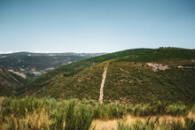 Small Road Crossing A Mountain Of Pine Trees With More Mountains