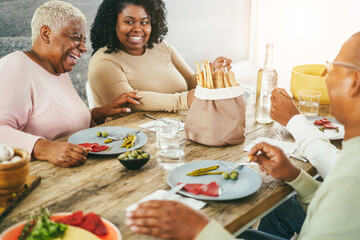 Wall Mural - Happy african family eating lunch together at home - Focus on mother face