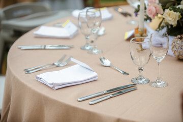 Classic table settings for fine dining with cutlery, glassware, flowers and candles. Props for events, weddings, birthdays, gala banquet.