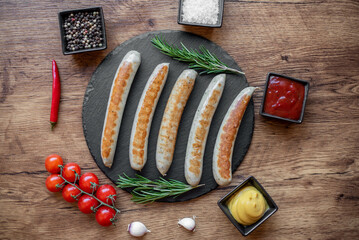 Wall Mural - grilled sausages with spices on a rustic background