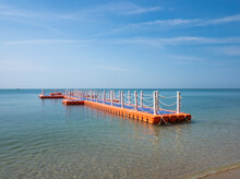 Orange And Blue Plastic Floating Pier With Protection Fence In The Sea. An Anchored Raft-like Platform, Often Referred To As A Pontoon. At Bang Saen Beach Chon Buri, Thailand