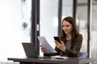 © Natee Meepian - Business woman using smartphone for do math finance on wooden desk in office, tax, accounting, financial concept.