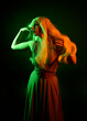 © faestock - portrait of pretty girl with blonde hair & elegant gown with expressive facial expressions & gestural arm poses. colourful neon gel lighting, isolated on black studio background.