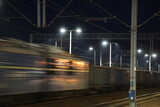 Fototapeta  - Pociąg towarowy w czasie jazdy po torach kolejowych nocną porą