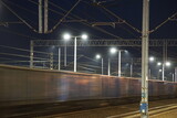 Fototapeta  - Pociąg towarowy w czasie jazdy po torach kolejowych nocną porą