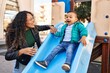 © Krakenimages.com - Mother and son playing on slide at park