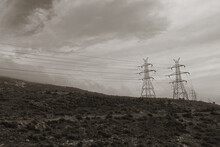 Pylons Overhead Power Lines On Mountain And Cloudy Sky