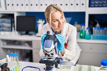 Sticker - Young blonde woman scientist using microscope working at laboratory