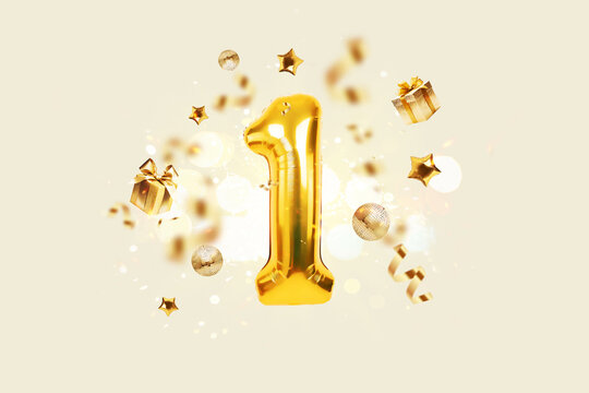 golden number 1 is flying with golden confetti, gifts, mirror ball and stars balloons on a beige bac