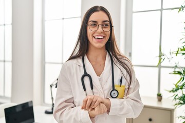 Canvas Print - Young beautiful hispanic woman doctor smiling confident standing at clinic