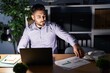 Young hispanic man business worker working overtime at office