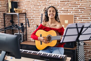 Canvas Print - Young african american woman musician playing classical guitar at music studio