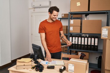 Sticker - Young hispanic man ecommerce business worker reading document at office