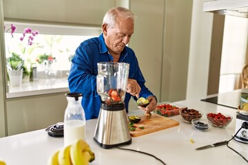 Poster - Senior man cutting avocado at kitchen