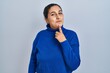 © Krakenimages.com - Young hispanic woman standing over isolated background thinking concentrated about doubt with finger on chin and looking up wondering