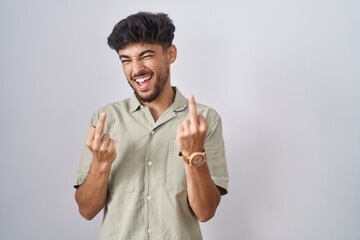 Sticker - Arab man with beard standing over white background showing middle finger doing fuck you bad expression, provocation and rude attitude. screaming excited