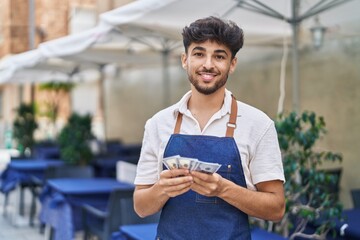 Sticker - Young arab man waiter counting dollars working at restaurant