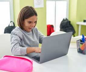 Sticker - Adorable hispanic boy student using laptop sitting on table at classroom