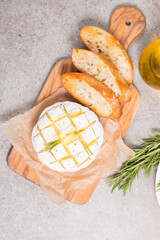 Wall Mural - Baked camembert soft cheese. Grilled brie with toasts and rosemary. 