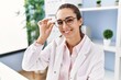 © Krakenimages.com - Young hispanic woman smiling confident wearing doctor uniform at clinic