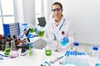 © Krakenimages.com - Young hispanic woman working at scientist laboratory relaxed with serious expression on face. simple and natural looking at the camera.