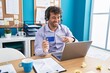 © Krakenimages.com - Hispanic young man working at the office doing online shopping smiling happy pointing with hand and finger