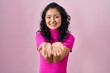 © Krakenimages.com - Young asian woman standing over pink background smiling with hands palms together receiving or giving gesture. hold and protection