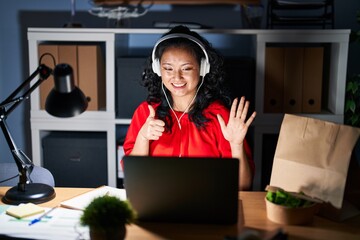 Wall Mural - Young asian woman working at the office with laptop at night showing and pointing up with fingers number six while smiling confident and happy.