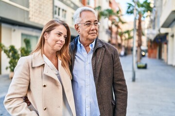 Canvas Print - Middle age man and woman couple smiling confident standing together at street