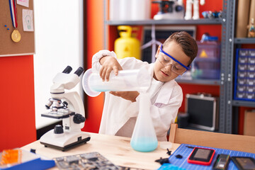 Poster - Adorable hispanic toddler student smiling confident pouring liquid on test tube at classroom