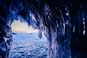 Wall Mural - Blue Ice cave or grotto on winter lake Baikal. Beautiful winter landscape with long icicles