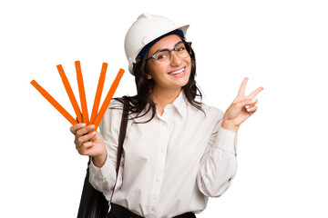 Wall Mural - Young architect indian woman with helmet and holding a meter cut out isolated joyful and carefree showing a peace symbol with fingers.