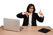 Young indian woman in a table with a laptop and tablet isolated showing thumbs up and thumbs down, difficult choose concept