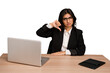 © Asier - Young indian woman in a table with a laptop and tablet isolated showing thumb down, disappointment concept.