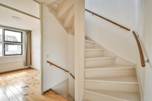 An Empty Room With Wood Flooring And White Painted Staircase Leading Up To The Second Floor In A Home For Sale