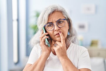 Poster - Middle age woman worried talking on the smartphone at home