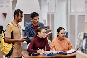 Wall Mural - Multiethnic group of young people studying using computer together