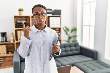 Sticker - African woman working at psychology clinic pointing up looking sad and upset, indicating direction with fingers, unhappy and depressed.