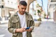 © Krakenimages.com - Young hispanic man smiling confident using smartphone at street